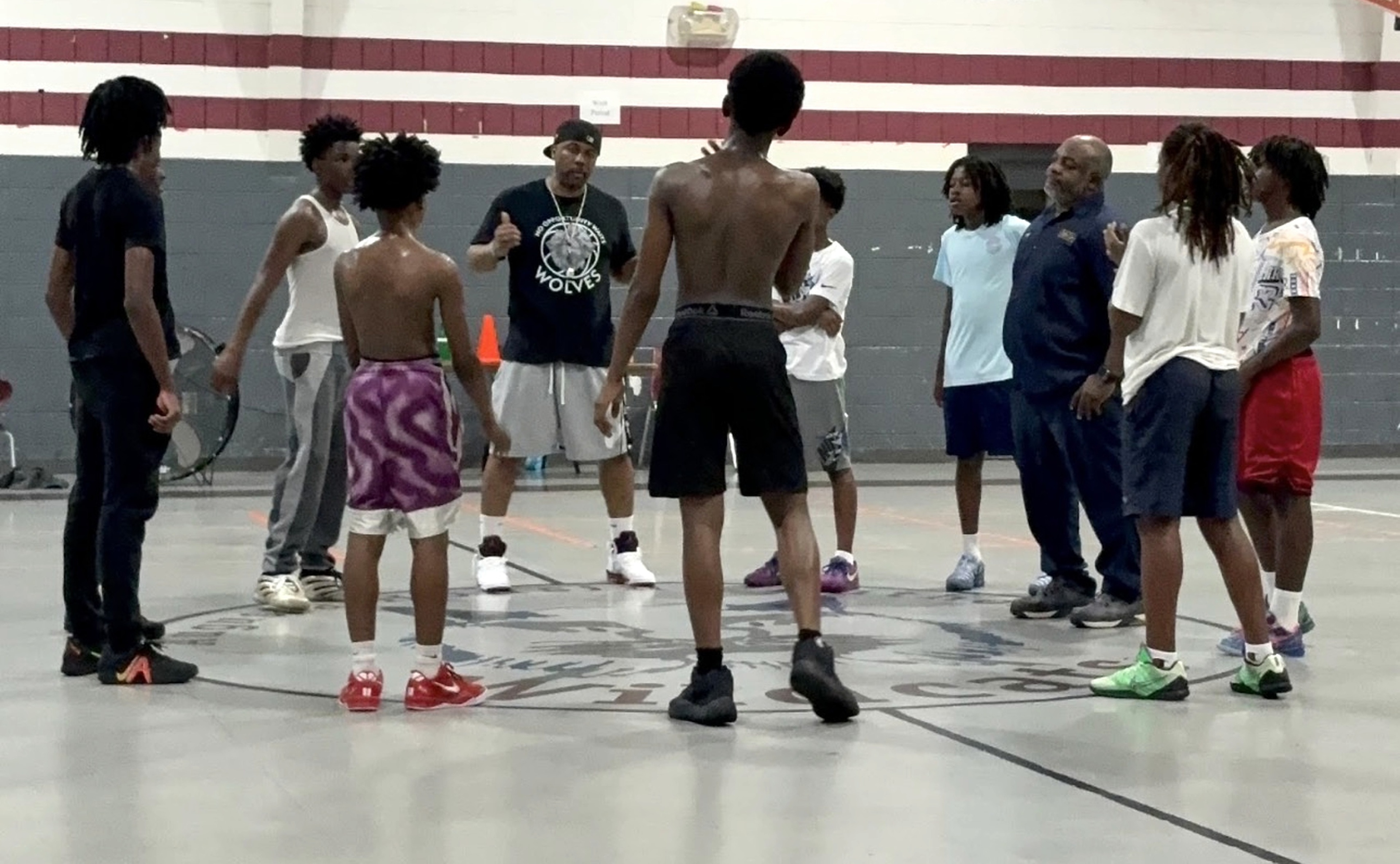 Young athletes and coaches gathered together on the basketball court