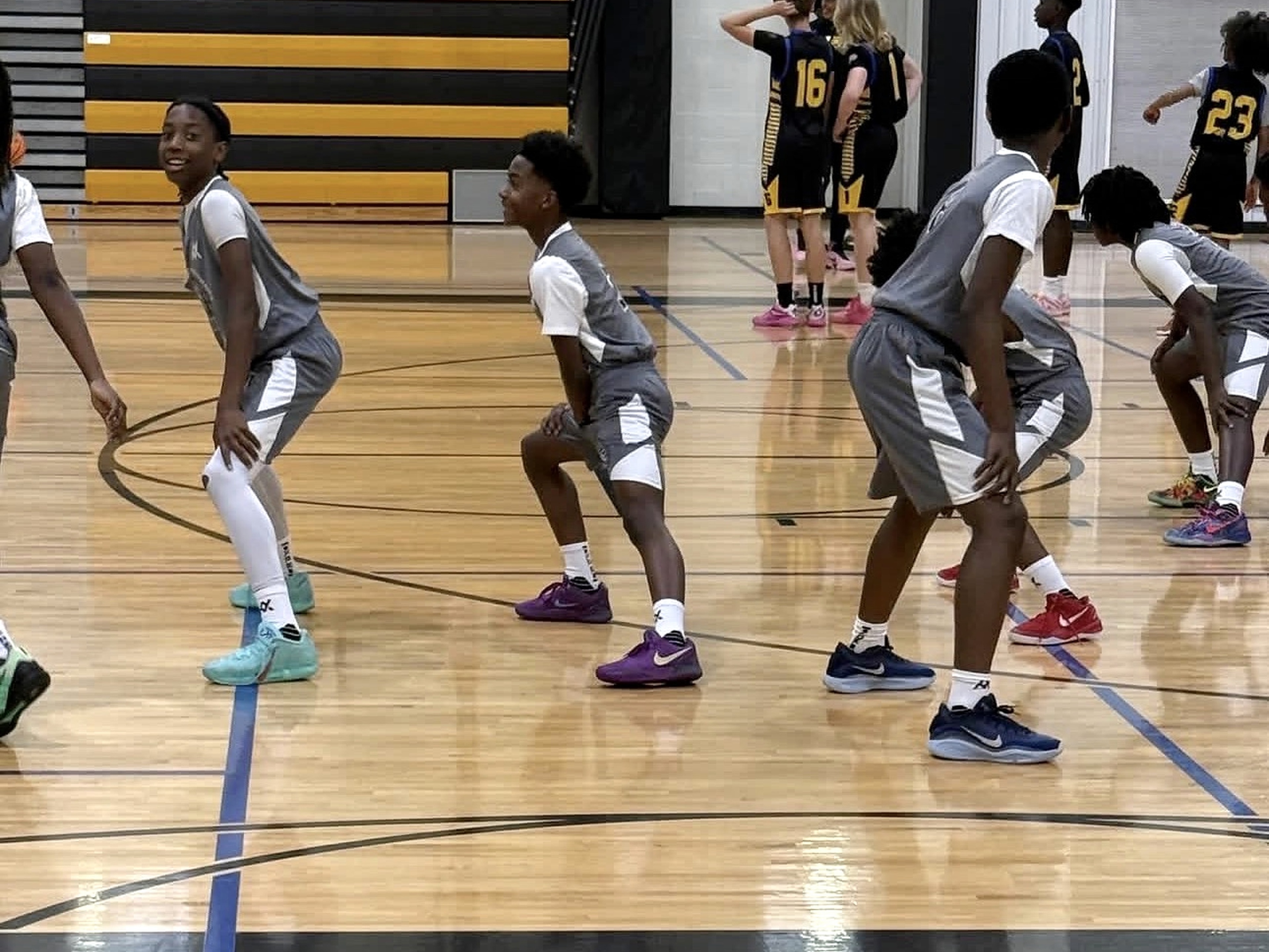 Wolves players in gray uniforms ready to defend during a basketball game